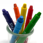 Twist up silky watercolor crayons in a glass jar against a white background