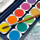 Close up of colorful watercolor paint set with a paintbrush