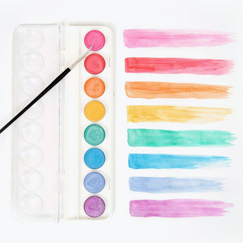 A set of metallic watercolor paints with swatches of color displayed next to a paintbrush, all arranged on a white background.