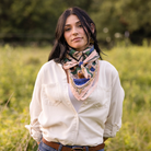 Woman wearing a pink fabric dandelion flower patterned scarf in a field