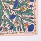 Detail corner of cotton banana dandelion patterned fabric with blue and green flowers on a pink background