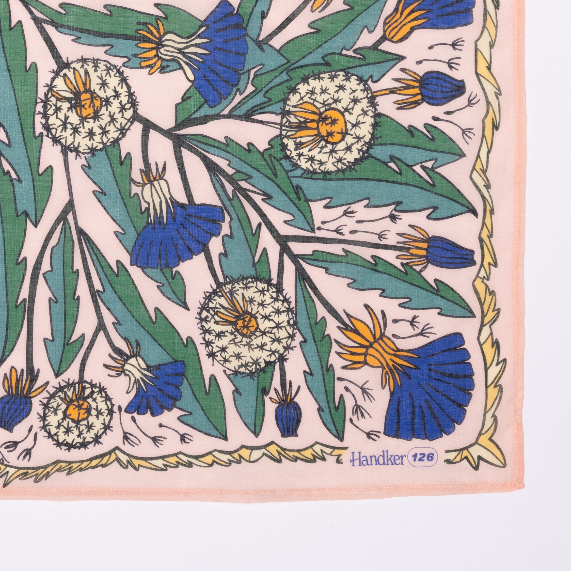 Detail corner of cotton banana dandelion patterned fabric with blue and green flowers on a pink background