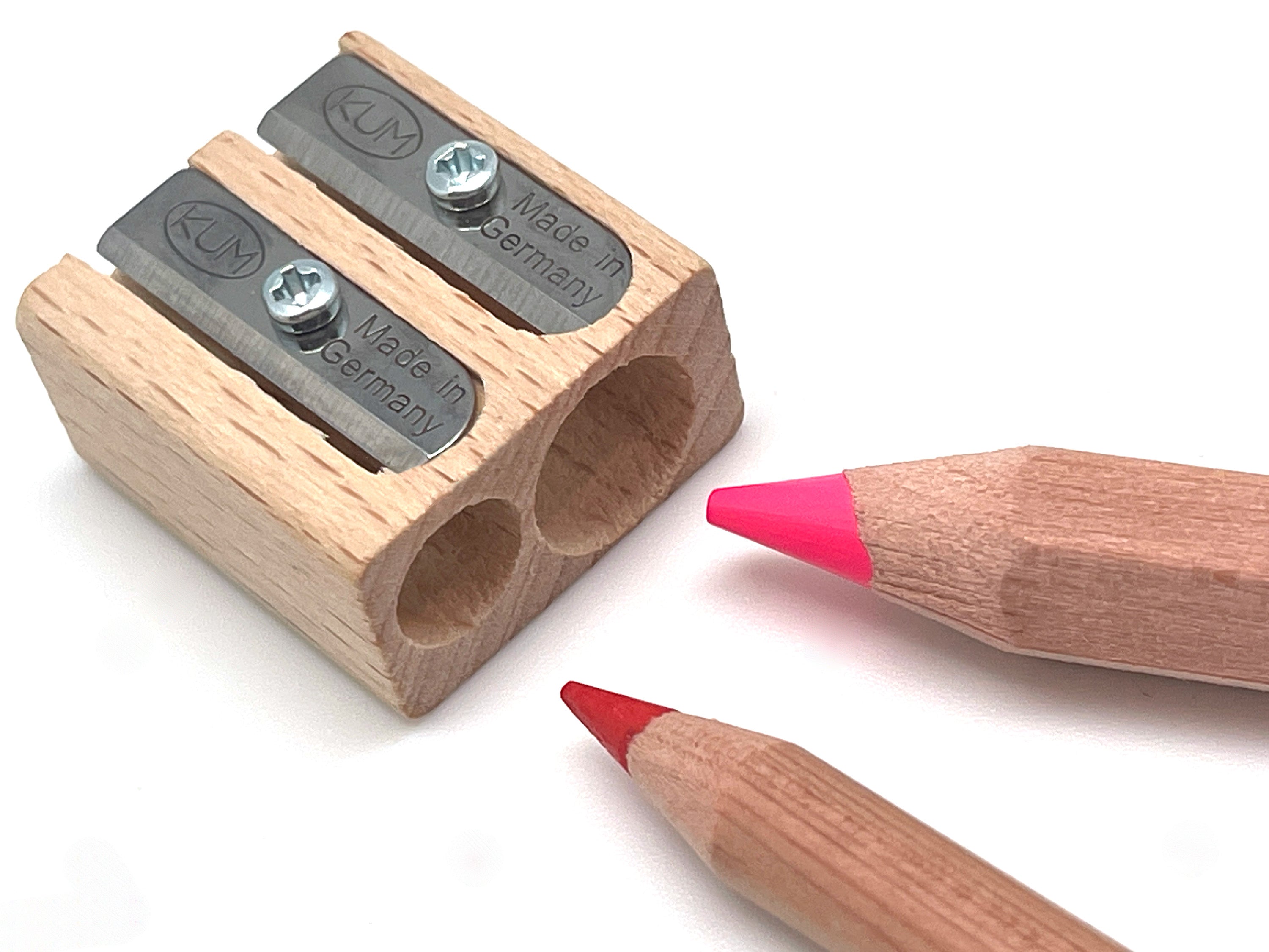 Wooden pencil sharpener with two sharpened pencils on a white background
