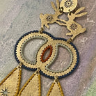 Textured brass handmade earrings with two hares dancing and color thread edges