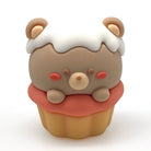 A small cupcake-shaped pencil sharpener with a light brown bear face and white frosting, and a yellow cupcake base, centered on a plain white background.