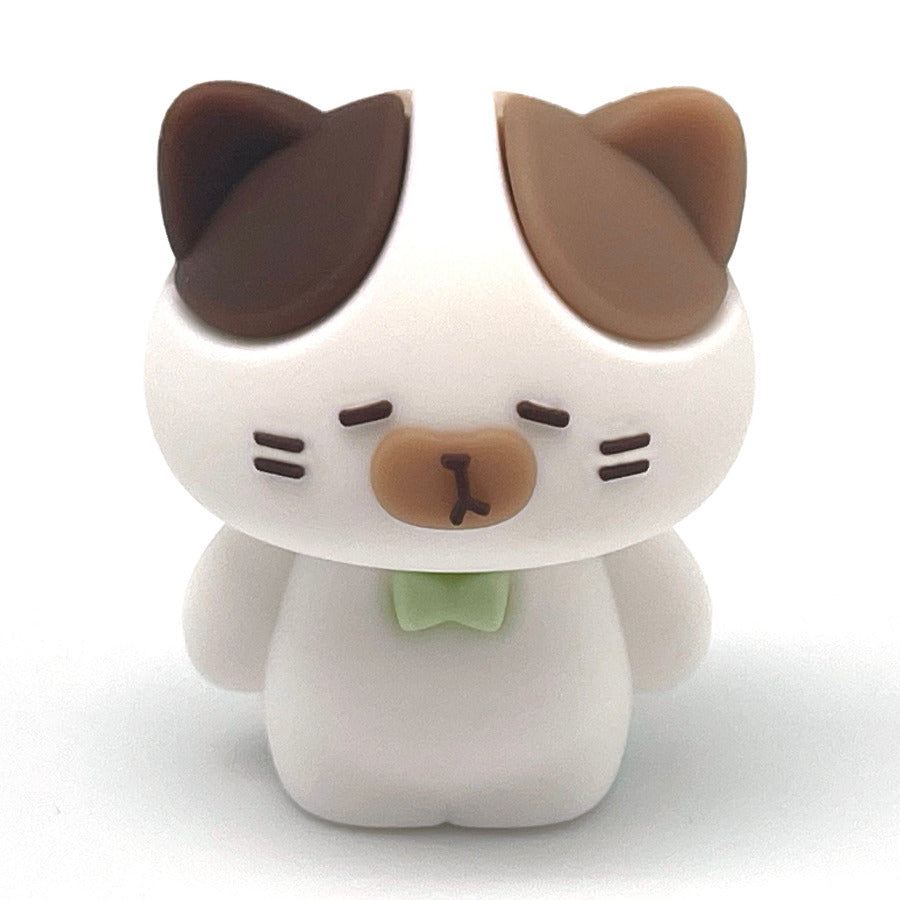 A small white cat pencil sharpener with brown ears, a brown nose, and a light green bow tie, centered on a plain white background.