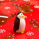 Penguin eraser on a red background with reindeer and snowflake pattern
