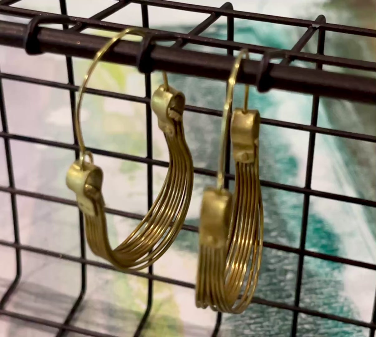 Video capture of hanging hoop earrings handmade from brass