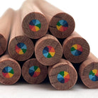 A close-up of several cedar wood pencils arranged in a stack, showing the circular multi-color rainbow swirl core on a white background.