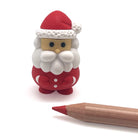 Small Santa Claus puzzle next to a wooden pencil on a white background