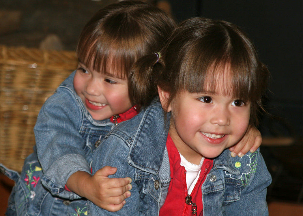 Happy twin toddlers smiling with blurred background