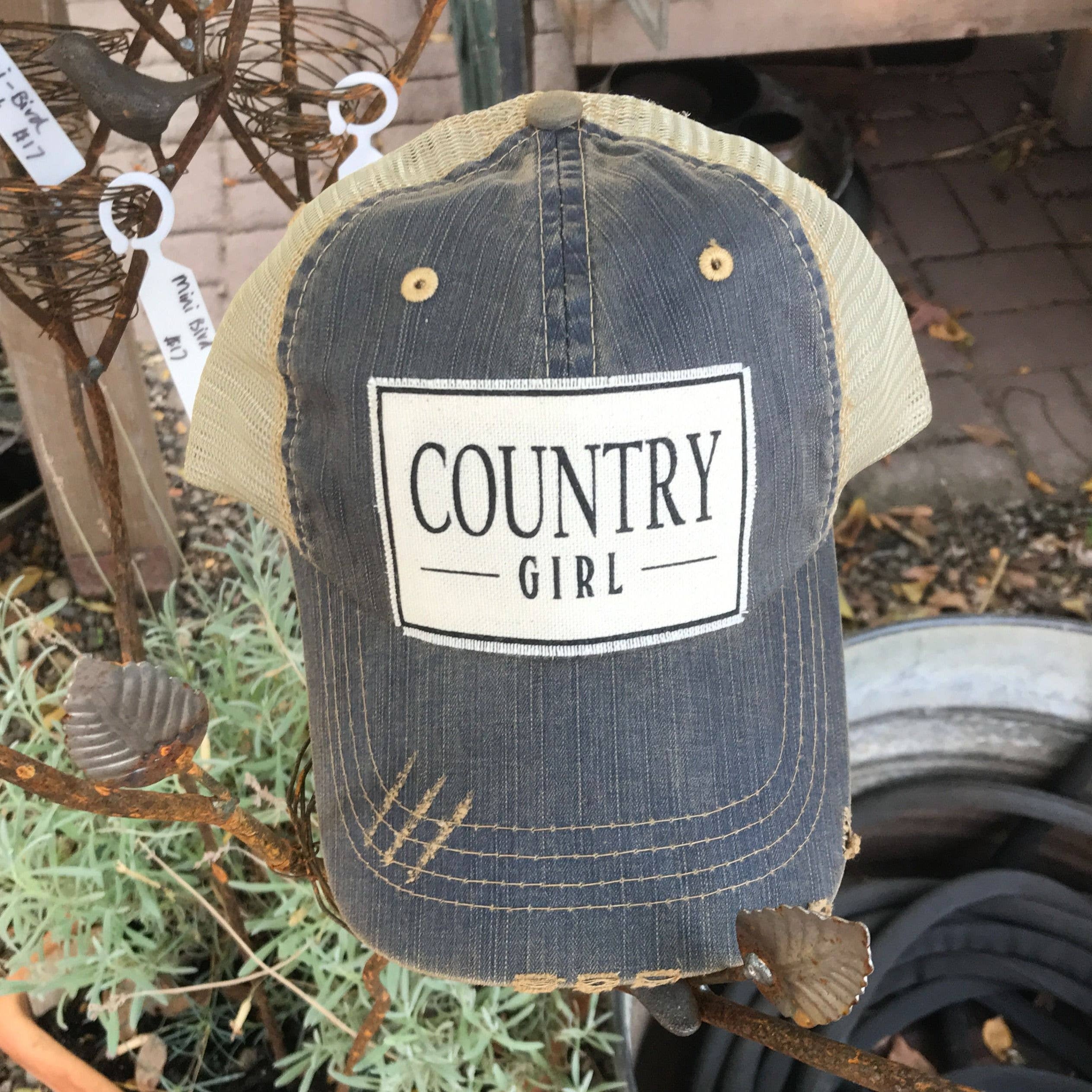 Blue cap with 'Country Girl' patch on a plant stand