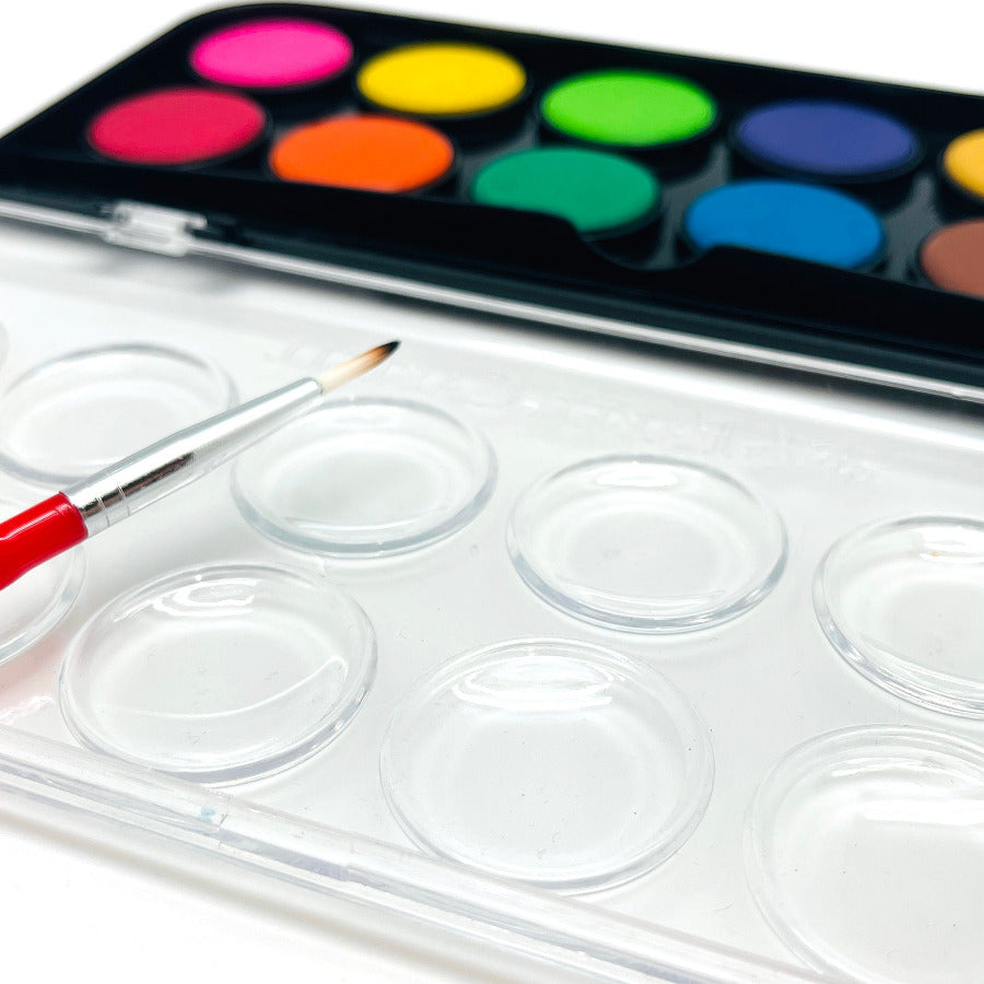 Open pallet of watercolor paints with a paint brush on a white background