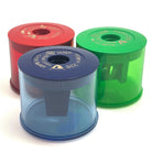 Three colorful KUM sharpeners for jumbo crayons or jumbo pencils (red, blue, green) on a white background